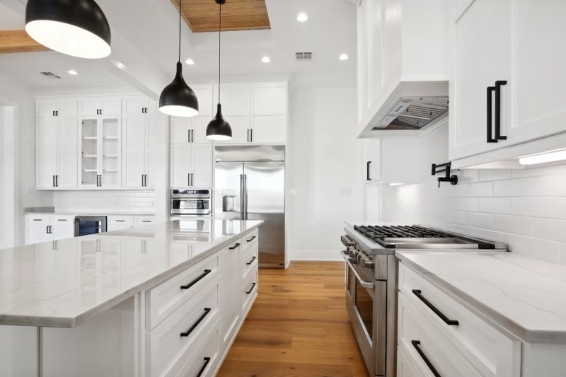White kitchen with marble island and stainless range