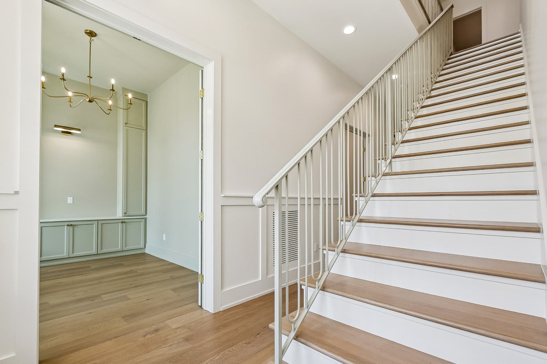 Staircase with white iron railing and built-in cabinets