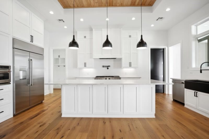 White kitchen with black pendants and large island