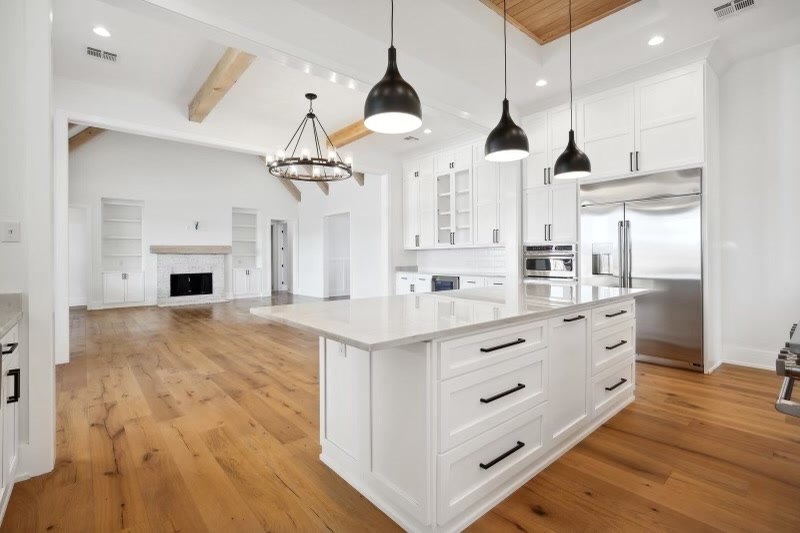Open kitchen with beam ceiling and living room beyond