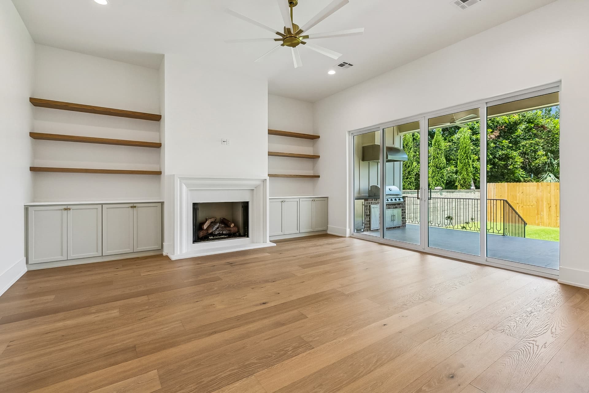 Living room with fireplace, built-ins, and outdoor kitchen view