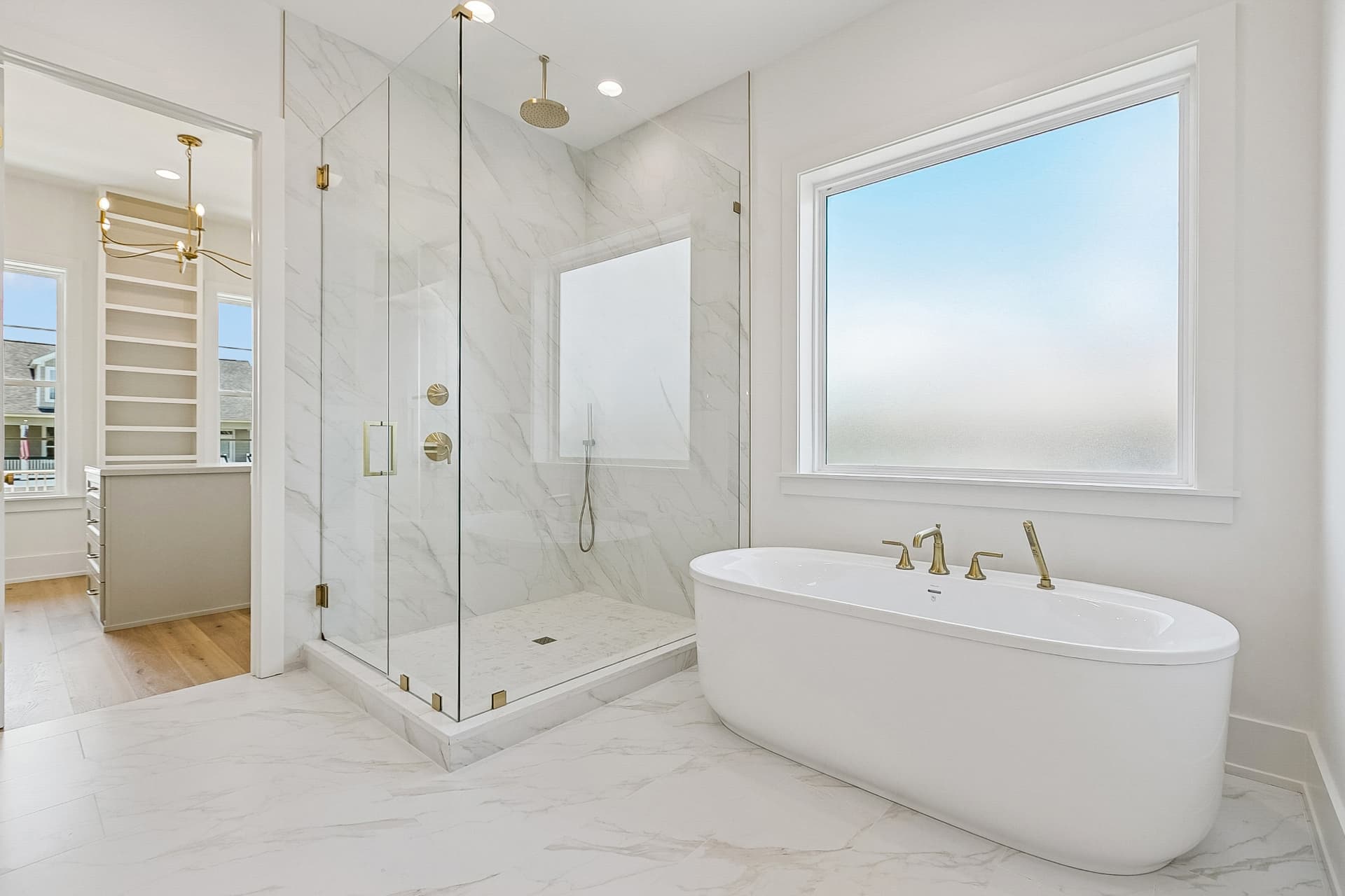 Marble primary bath with freestanding tub and glass shower