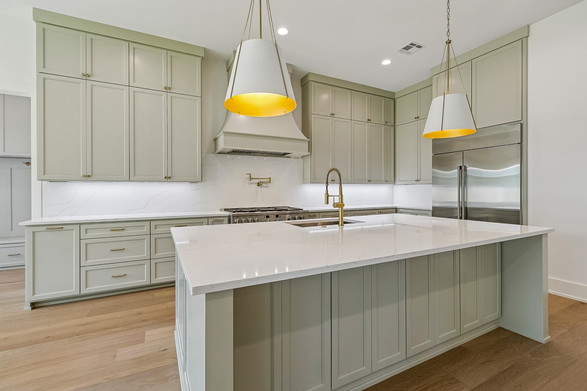 Custom kitchen with sage green cabinets and large island