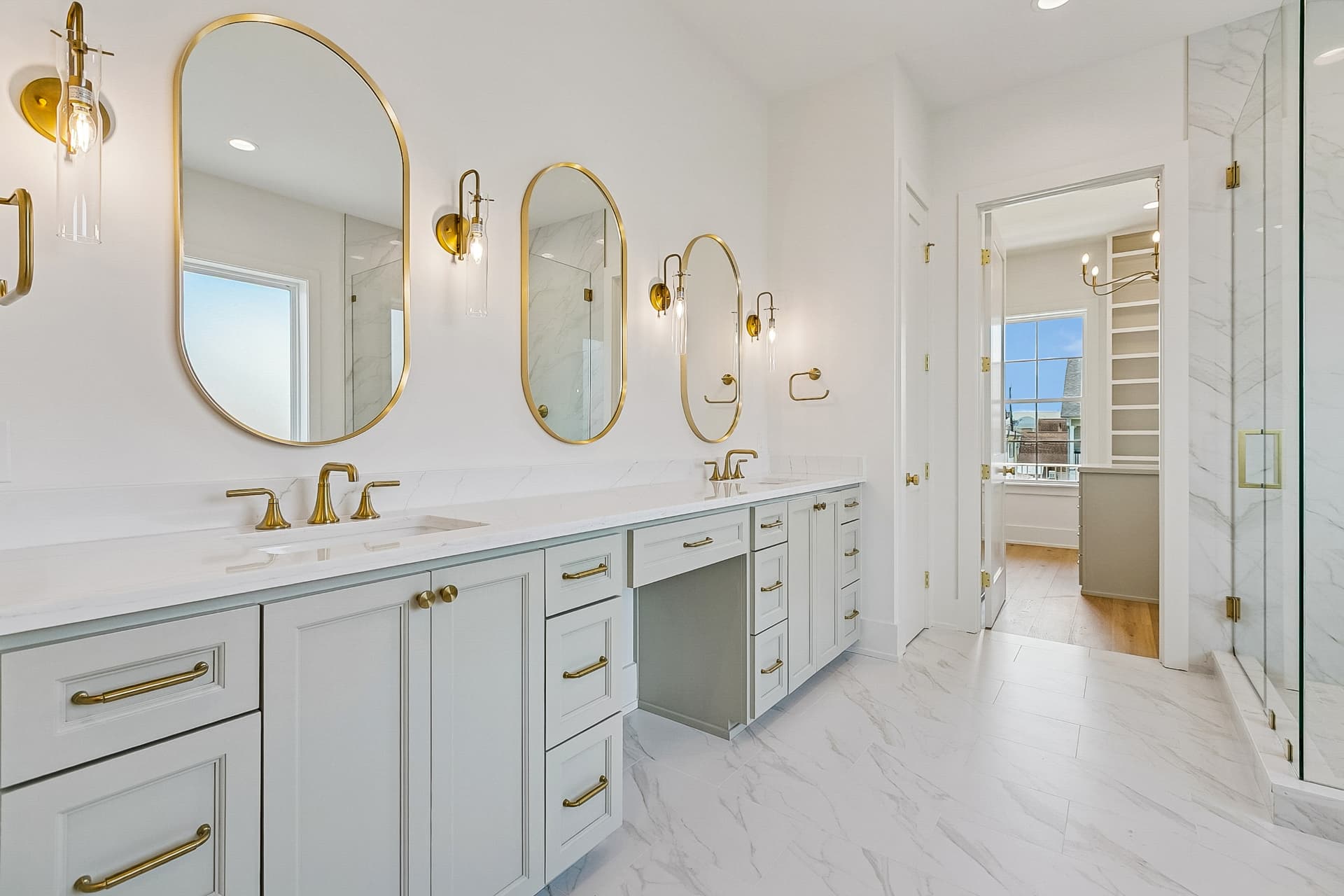 Primary bath with double vanity and gold-framed mirrors